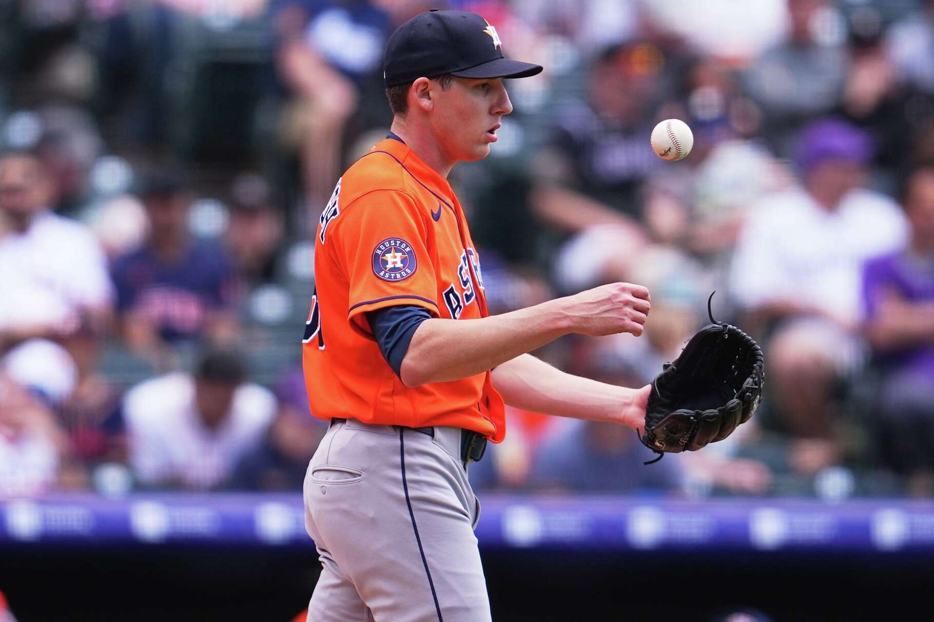 Houston Astros relief pitcher AJ Blubaugh tosses a new ball in the air after throwing a wild pitch to allow in a run in the second inning of a baseball game against the Colorado Rockies Wednesday, April 8, 2026, in Denver. (AP Photo/David Zalubowski)