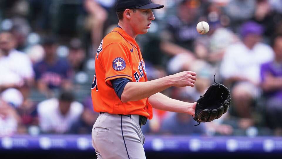Houston Astros relief pitcher AJ Blubaugh tosses a new ball in the air after throwing a wild pitch to allow in a run in the second inning of a baseball game against the Colorado Rockies Wednesday, April 8, 2026, in Denver. (AP Photo/David Zalubowski)