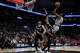 San Antonio Spurs guard De'aaron Fox (4) makes a jump shot over Portland Trail Blazers forward Toumani Camara (33) and center Donovan Clingan (23) during a home game at Frost Bank Center in San Antonio, Wednesday, April 8, 2026.