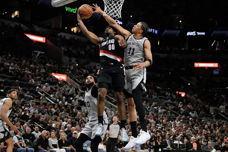 Spurs forward Carter Bryant defends Blazers guard Scoot Henderson during the first half of San Antonio's 112-101 win over Portland at the Frost Bank Center.