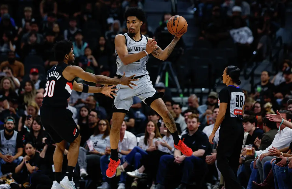 San Antonio Spurs guard Dylan Harper (2) makes a pass around Portland Trail Blazers guard Scoot Henderson (00) during an NBA game at Frost Bank Center in San Antonio, Wednesday, April 8, 2026. The Spurs defeated the Trail Blazers 112-101.
