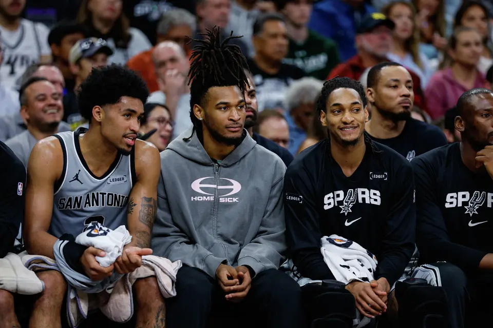 San Antonio Spurs guard Dylan Harper, guard Stephon Castle and guard Devin Vassell (24) talk on the bench as they watch their teammates play against the Portland Trail Blazers at Frost Bank Center in San Antonio, Wednesday, April 8, 2026. The Spurs defeated the Trail Blazers 112-101.