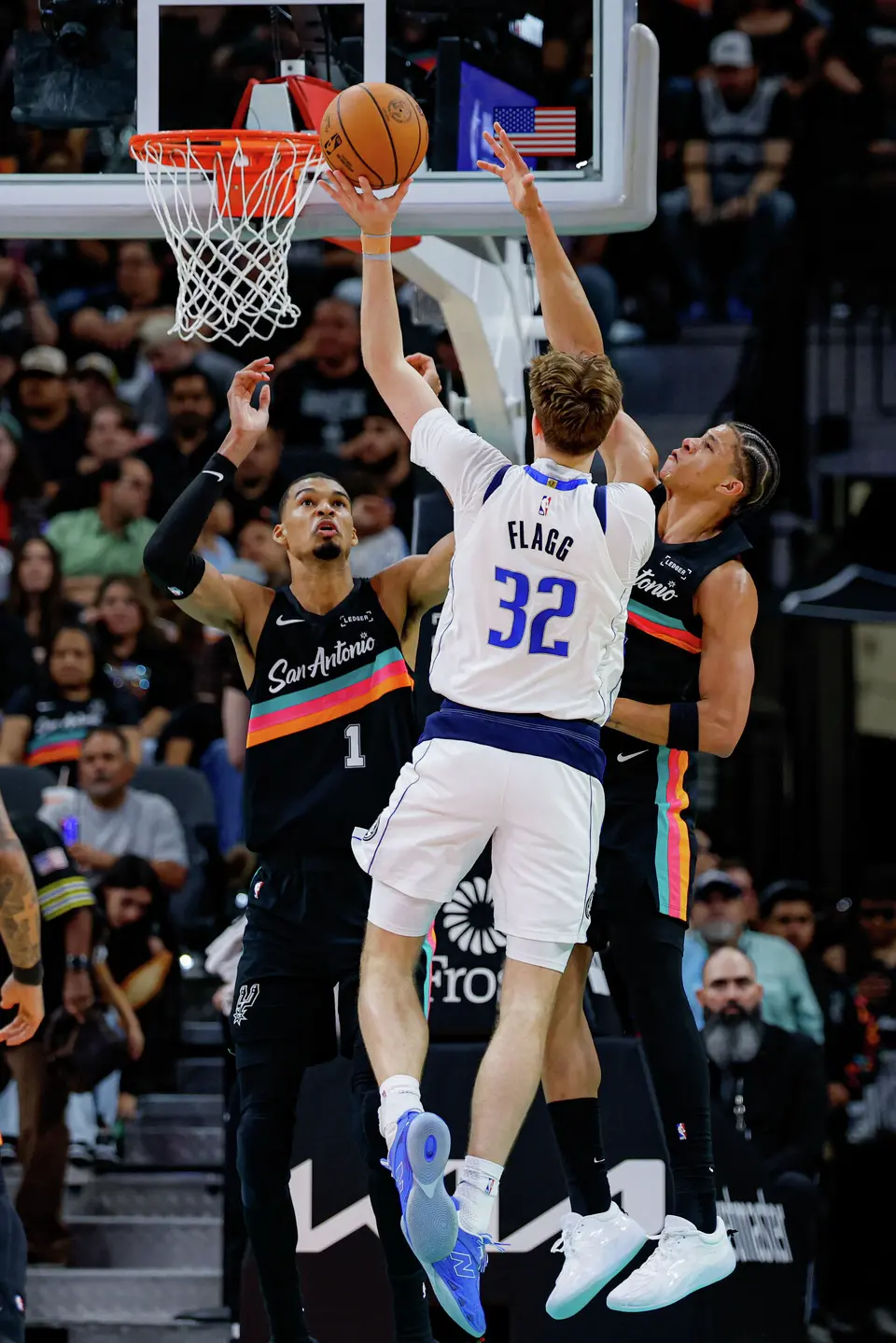 Dallas Mavericks forward Cooper Flagg (32) shoots over San Antonio Spurs forward Victor Wembanyama (1) and forward Carter Bryant (11) during an NBA game at Frost Bank Center in San Antonio, Friday, April 10, 2026. The Spurs won 139-120.