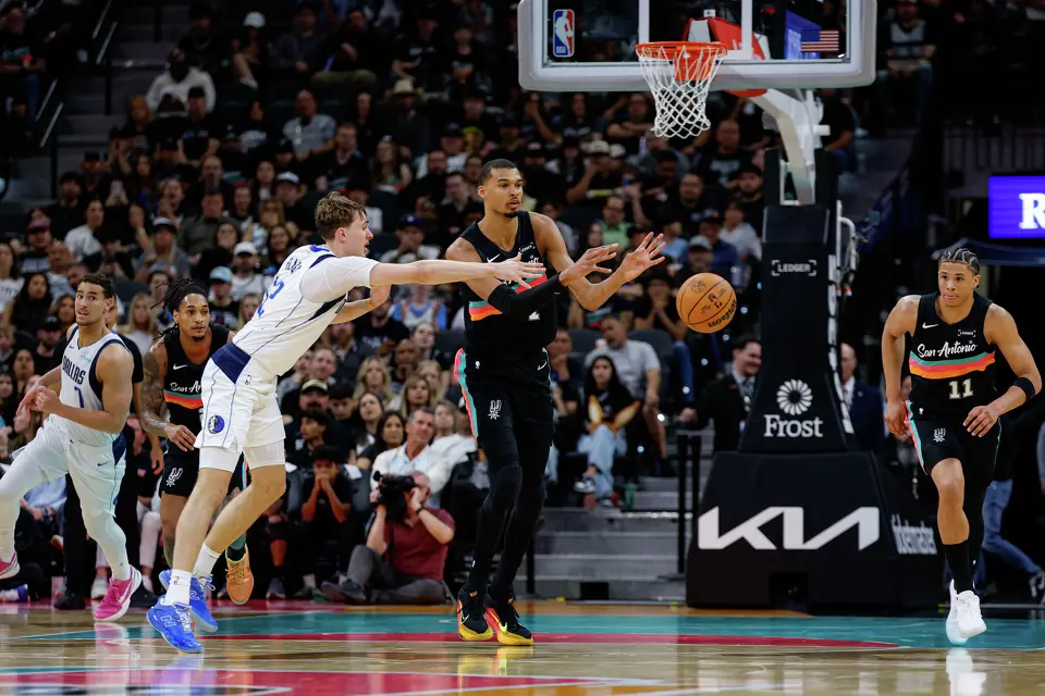 San Antonio Spurs forward Victor Wembanyama (1) makes a pass away from Dallas Mavericks forward Cooper Flagg (32) during the second quarter at Frost Bank Center in San Antonio, Friday, April 10, 2026. The Spurs won 139-120.