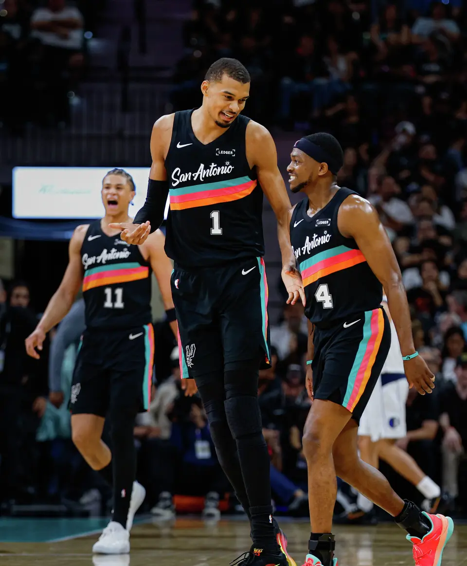 San Antonio Spurs forward Victor Wembanyama (1) and guard De'aaron Fox (4) talk as they head into a fourth quarter timeout against the Dallas Mavericks at Frost Bank Center in San Antonio, Friday, April 10, 2026. The Spurs won 139-120.