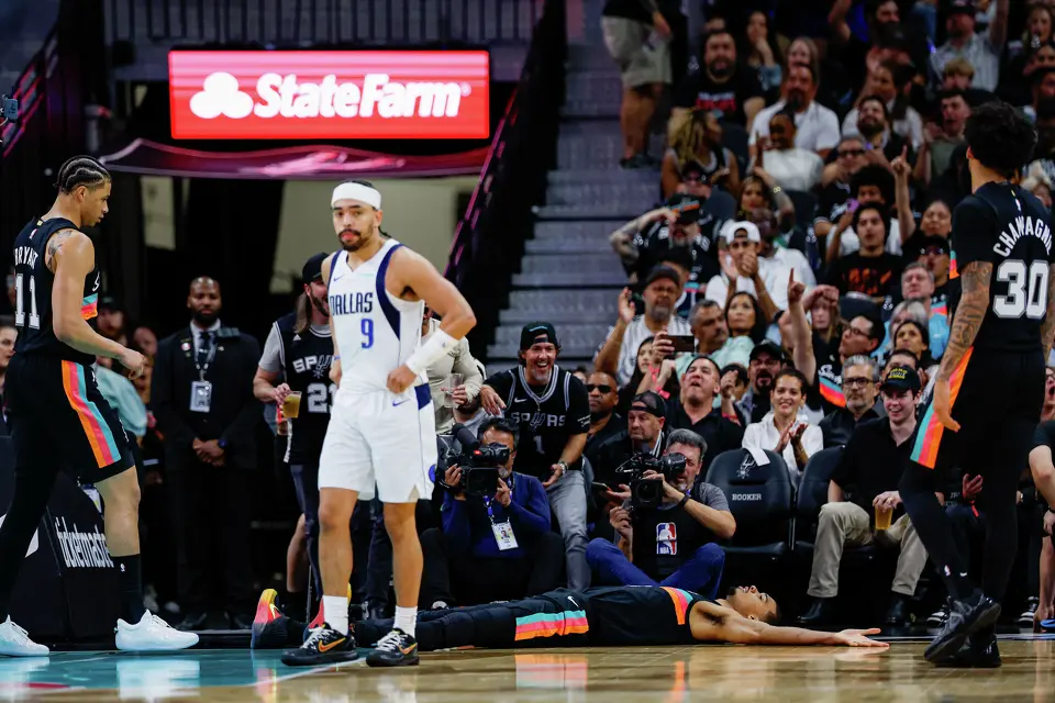 San Antonio Spurs forward Victor Wembanyama (1) falls to the ground after being fouled by the Dallas Mavericks under the net during the fourth quarter at Frost Bank Center in San Antonio, Friday, April 10, 2026. The Spurs won 139-120.