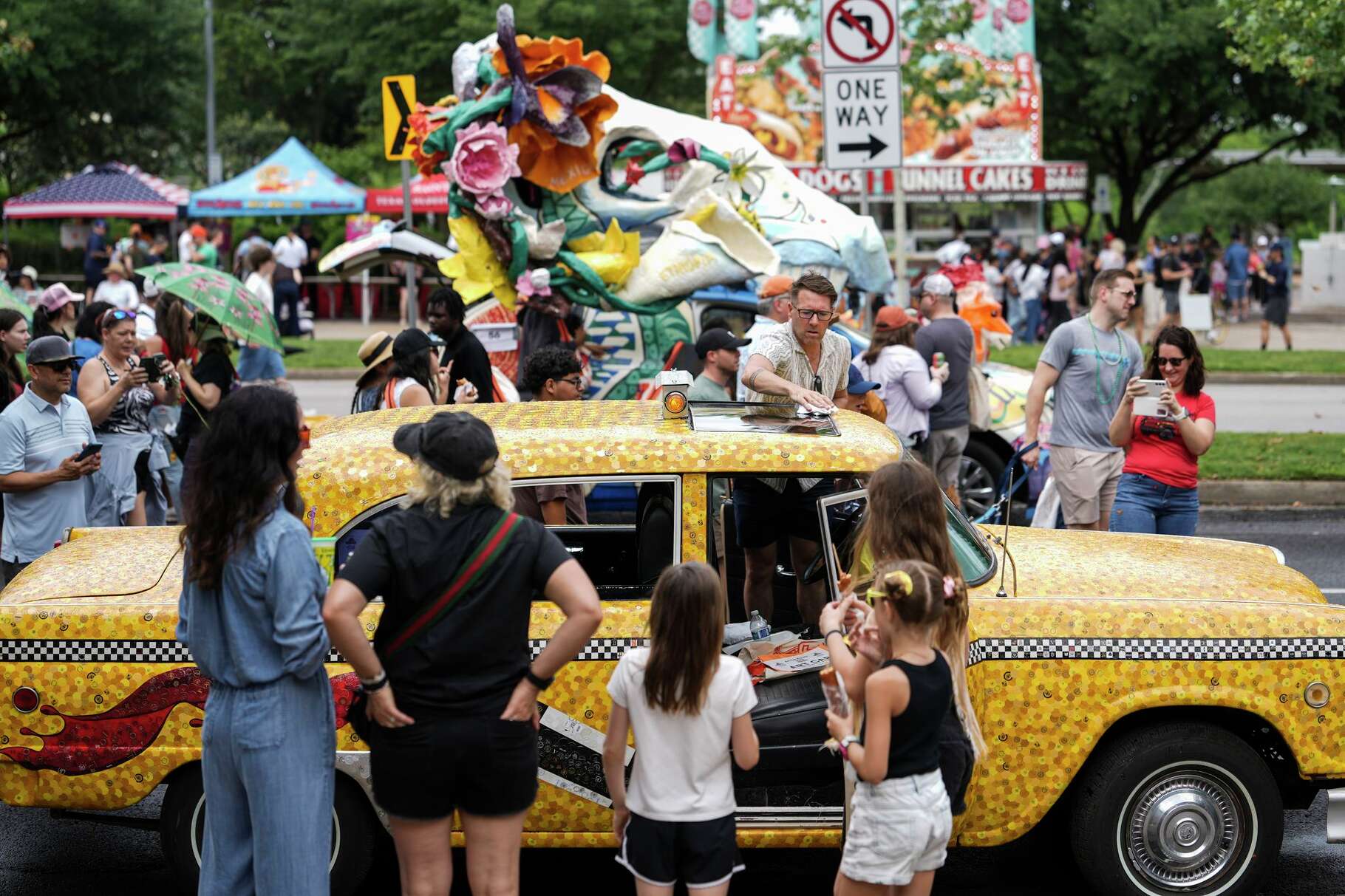 Clay Williams wipes down an art car after light rain during the annual Art Car Parade in downtown Houston, Saturday, April 11, 2026.