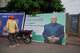 A motorcyclist stands beside a billboard featuring presidential candidate Paul Hounkpe in Cotonou, Benin, Friday, April 10, 2026.
