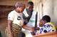 A woman is verified before casting her ballot at a polling station in Cotonou, Benin, Sunday, April 12, 2026.