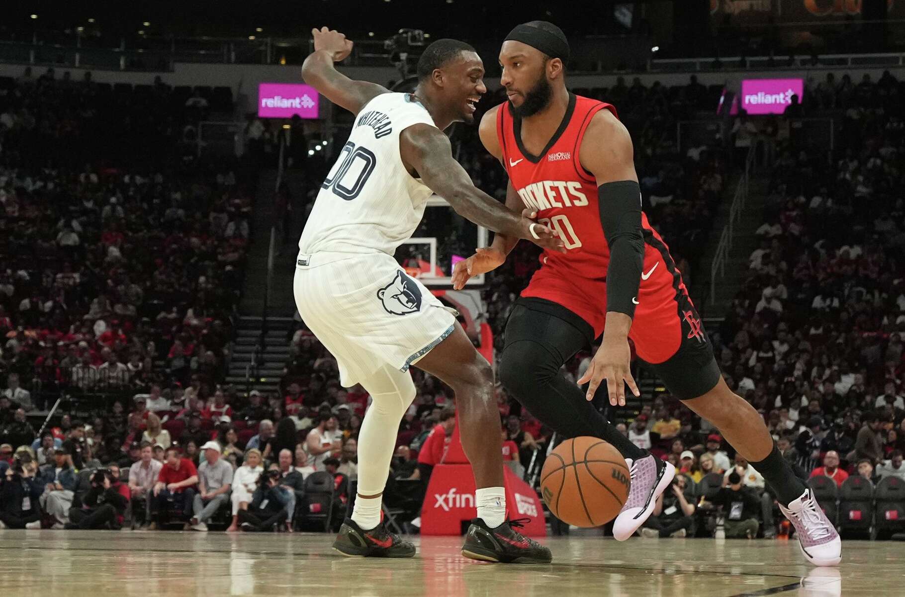 Houston Rockets guard Josh Okogie (20) drives to the basket around Memphis Grizzlies forward Dariq Whitehead (00) in the first half of game action at the Toyota Center in Houston on Sunday, April 12, 2026.
