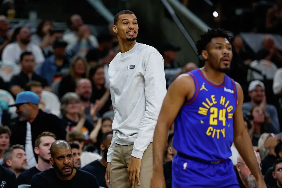San Antonio Spurs forward Victor Wembanyama reacts after watching San Antonio Spurs forward Carter Bryant (11) dunk on Denver Nuggets center Nikola Jokic (15) during the first quarter at Frost Bank Center in San Antonio, Sunday, April 12, 2026.