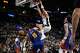 San Antonio Spurs forward Carter Bryant (11) dunks over Denver Nuggets center Nikola Jokic during the first half of an NBA basketball game, Sunday, April 12, 2026, in San Antonio.