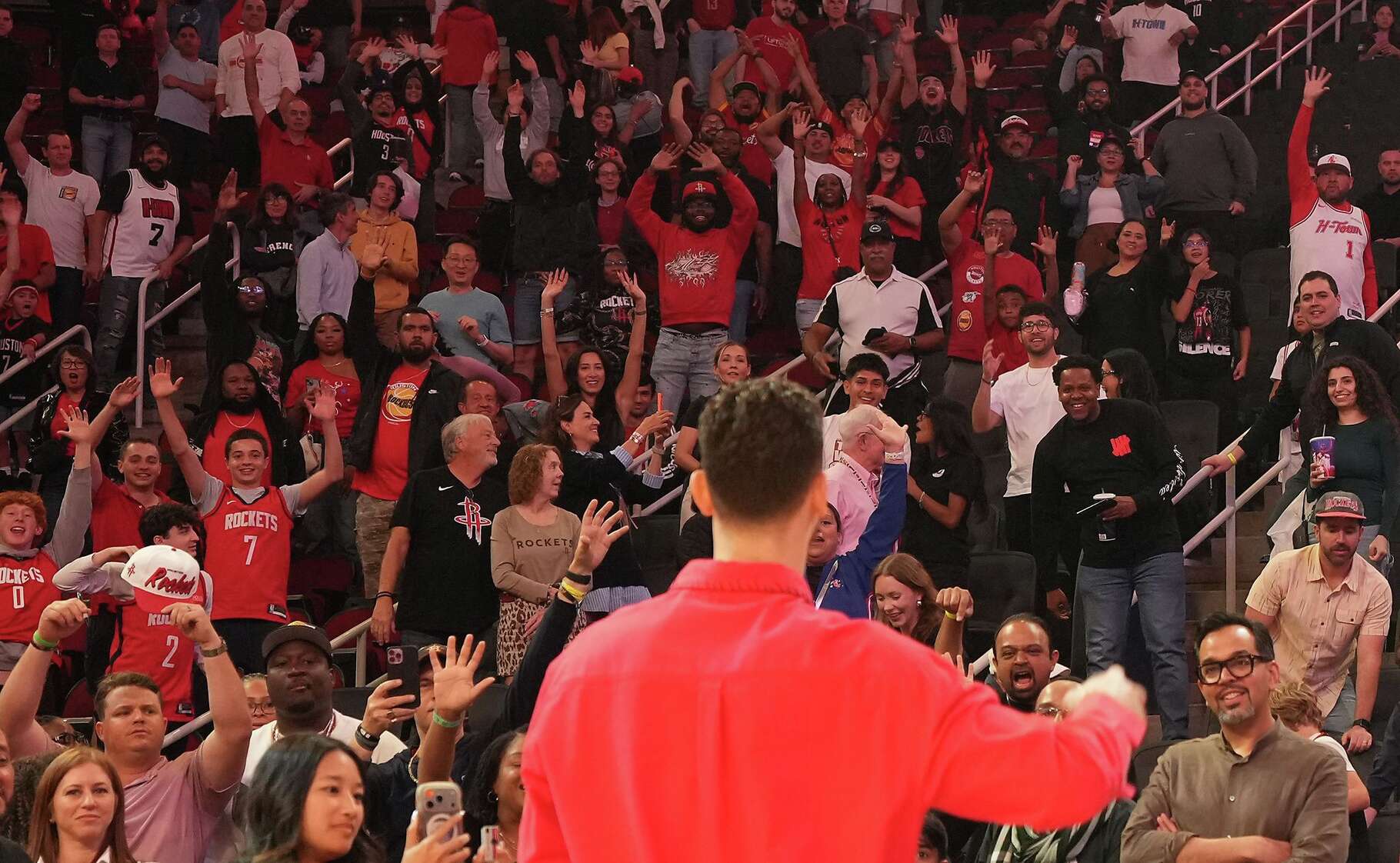 Houston Rockets fans try to get Houston Rockets center Alperen Sengun (28) attention for a signed basketball after the team took down the Memphis Grizzlies at the Toyota Center in Houston on Sunday, April 12, 2026. Houston Rockets won the game 132-101.