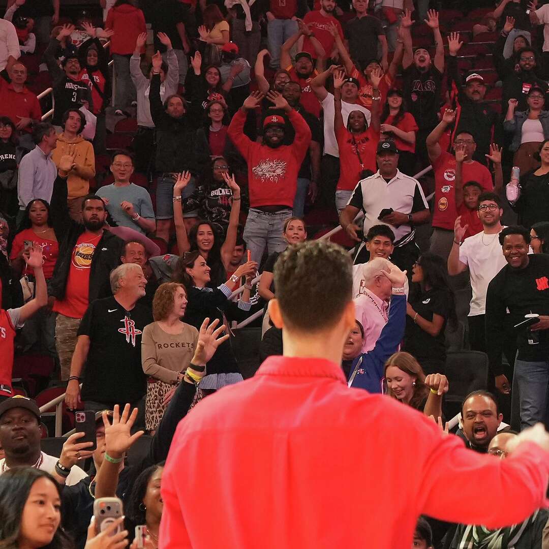 Houston Rockets fans try to get Houston Rockets center Alperen Sengun (28) attention for a signed basketball after the team took down the Memphis Grizzlies at the Toyota Center in Houston on Sunday, April 12, 2026. Houston Rockets won the game 132-101.