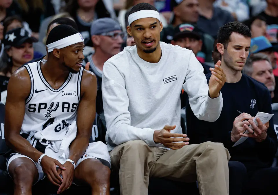 San Antonio Spurs guard De'aaron Fox (4) and forward Victor Wembanyama (1) talk on the bench during the first quarter against the Denver Nuggets at Frost Bank Center in San Antonio, Sunday, April 12, 2026. The Spurs lost 128-118 to the Nuggets in their final regular-season game.
