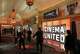 FILE - Attendees walk past a Cinema United advertisement at CinemaCon in Las Vegas on April 2, 2025.