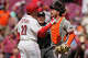 Cincinnati Reds' Sal Stewart, left, and San Francisco Giants catcher Patrick Bailey, right, argue as home plate umpire Junior Valentine, center, moves in after Stewart strikes out swinging for the final out in the ninth of a baseball game in Cincinnati, Thursday, April 16, 2026.