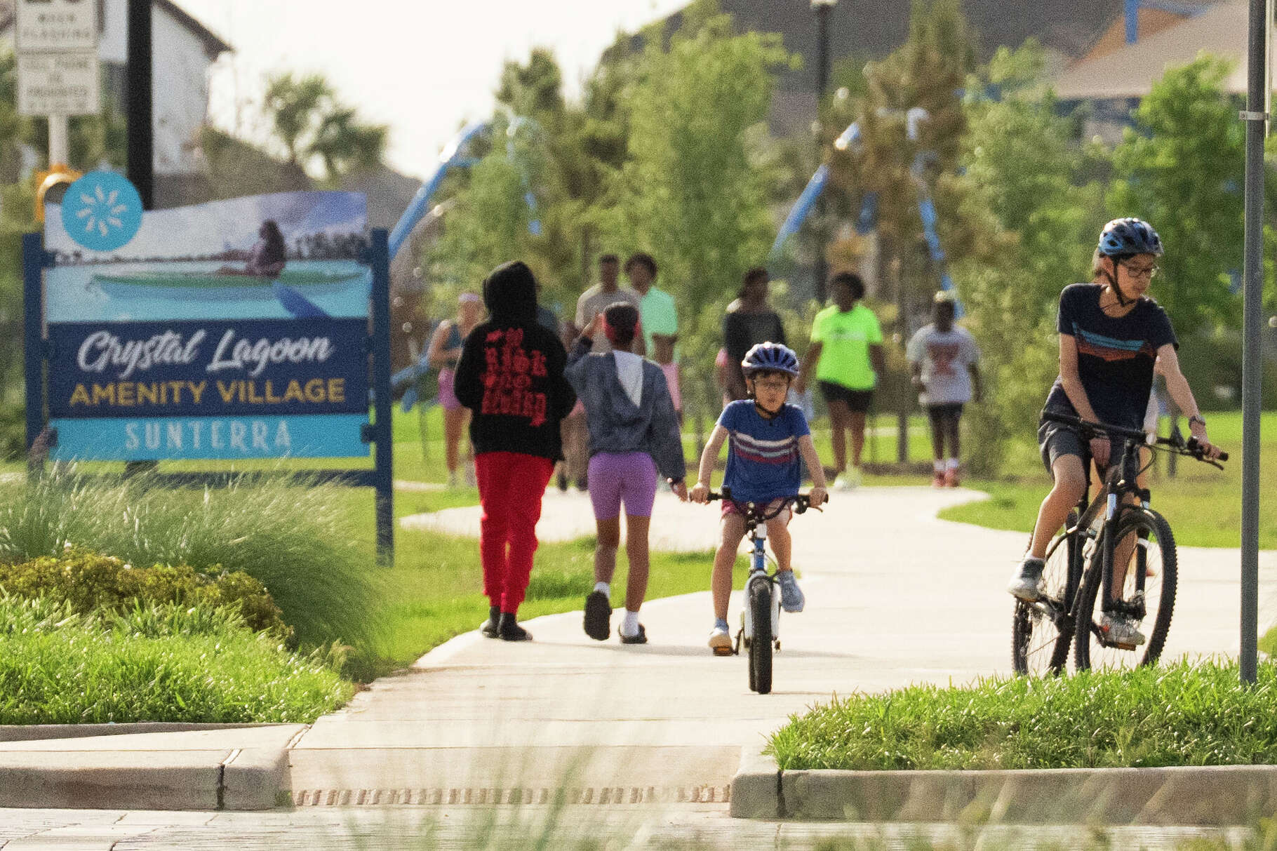 People bike along a path in Sunterra, a community of 7,000 homes in the Katy area, Wednesday, April 15, 2026.