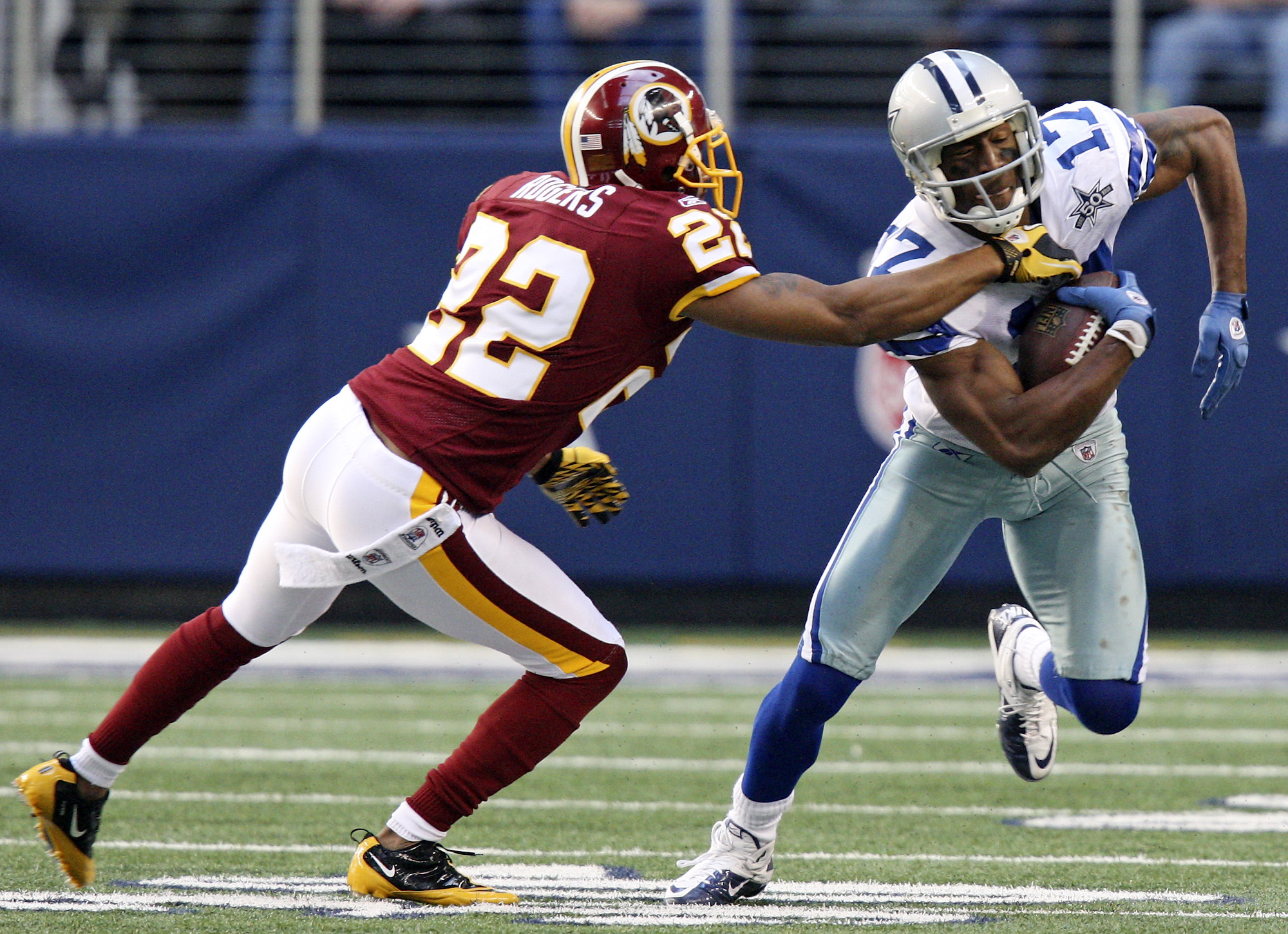 Dallas Cowboys tight end Jason Witten (82) stiff arms Washington Redskins  strong safety DeJon Gomes (24) on a 4-yard pass play in the third quarter  at Cowboys Stadium in Arlington, Texas, on Thanksgiving Day, Thursday,  November 22, 2012. The