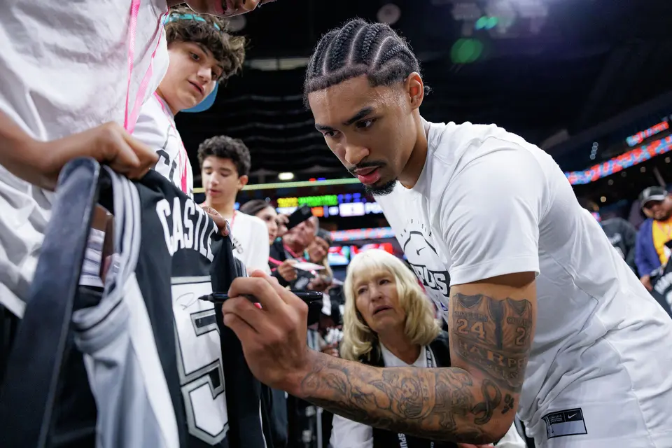 San Antonio Spurs guard Dylan Harper (2) signs autographs for fans before the start of Game 1 of a first-round NBA playoff series against the Portland Trail Blazers at Frost Bank Center, Sunday, April 19, 2026, in San Antonio.
