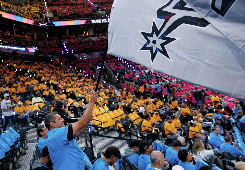 Bradley Garica waves a San Antonio Spurs flag before the start of Game 1 of a first-round NBA playoff series against the Portland Trail Blazers at Frost Bank Center, Sunday, April 19, 2026, in San Antonio.