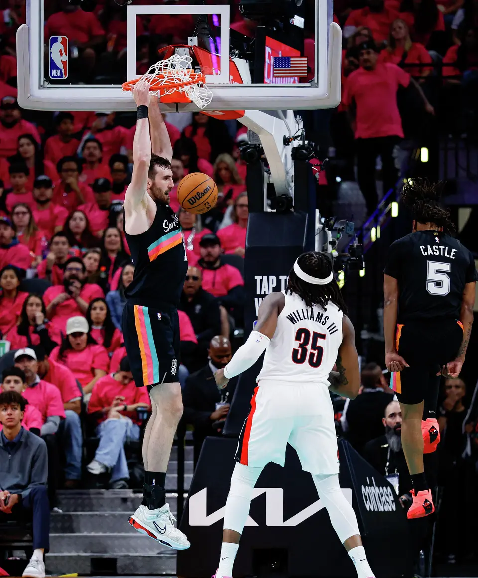 San Antonio Spurs center Luke Kornet (7) dunks after receiving a pass from guard Stephon Castle (5) during the second half of Game 1 of a first-round NBA playoff series against the Portland Trail Blazers at Frost Bank Center on Sunday, April 19, 2026, in San Antonio. The Spurs won 111-98.