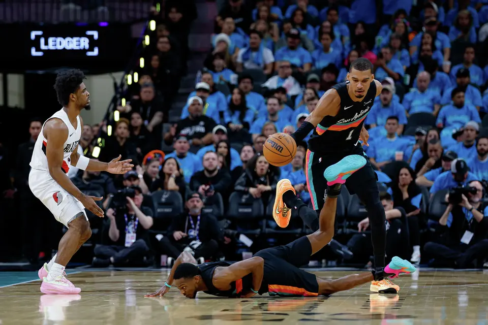 San Antonio Spurs forward Victor Wembanyama (1) recovers the ball after guard De'aaron Fox (4) falls to the ground during the first half of Game 1 of a first-round NBA playoff series against the Portland Trail Blazers at Frost Bank Center, Sunday, April 19, 2026, in San Antonio.
