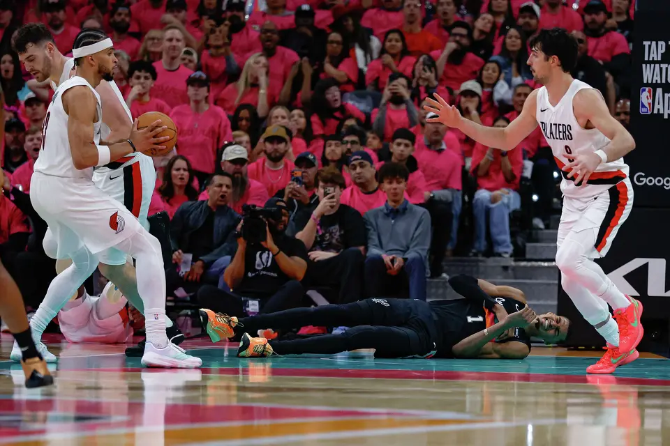 San Antonio Spurs forward Victor Wembanyama (1) falls to the ground after colliding with Portland Trail Blazers guard Jrue Holiday (5) during the second half of Game 1 of a first-round NBA playoff series at Frost Bank Center, Sunday, April 19, 2026, in San Antonio. The Spurs won 111-98.