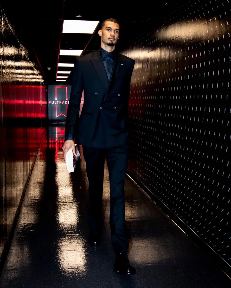 Spurs center Victor Wembanyama arrives at the Frost Bank Center for Game 1 of the Spurs' playoff series with Portland on Sunday, April 19, 2026, dressed in a custom-made black suit bought by teammate Kelly Olynyk.