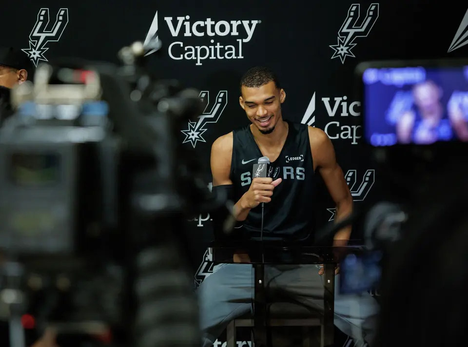 San Antonio Spurs’ Victor Wembanyama talks to reporters about being named NBA Defensive Player of the Year during shoot around practice at Victory Capital Performance Center in San Antonio, Tuesday, April 21, 2026. The 22-year-old Frenchman is the youngest player to win the award and the first to do so unanimously.