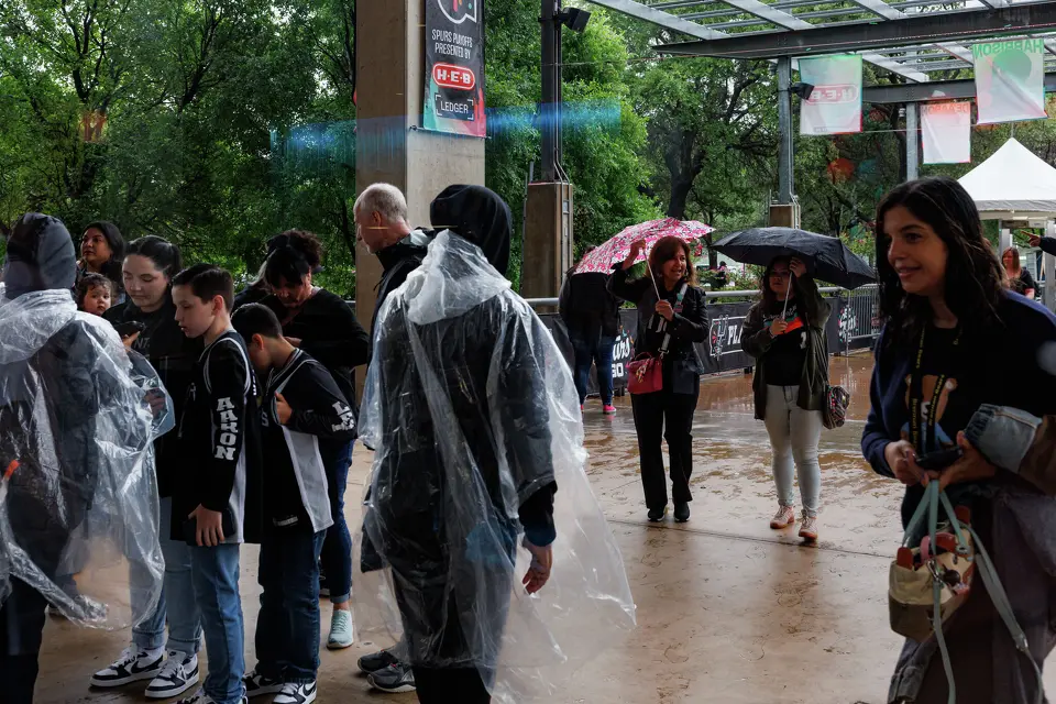People enter Frost Bank Center in the rain before Game 2 of a first-round NBA playoff series between the San Antonio Spurs and the Portland Trail Blazers in San Antonio, Tuesday, April 21, 2026.