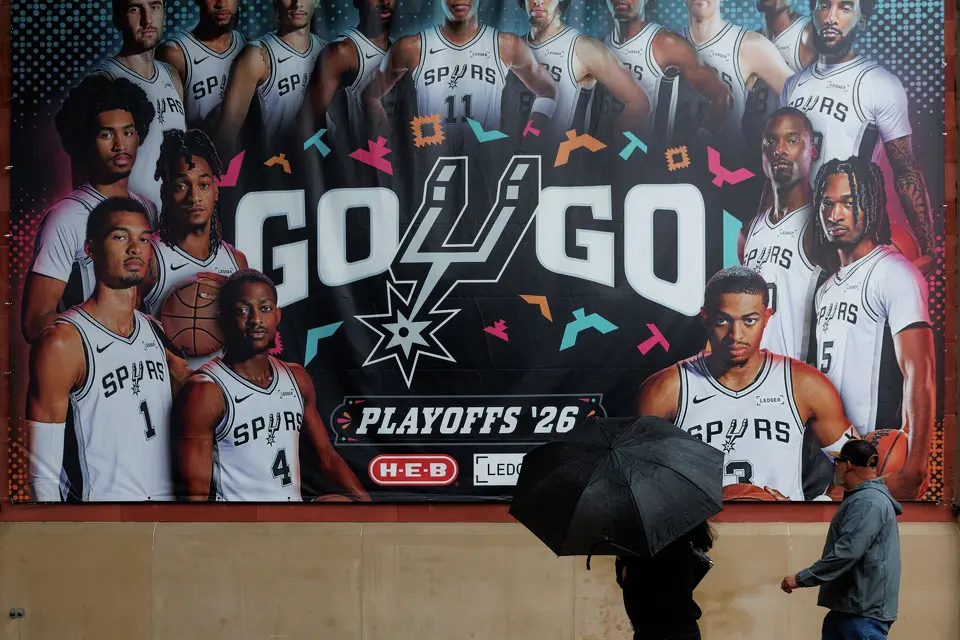 People enter Frost Bank Center in the rain before Game 2 of a first-round NBA playoff series between the San Antonio Spurs and the Portland Trail Blazers in San Antonio, Tuesday, April 21, 2026.
