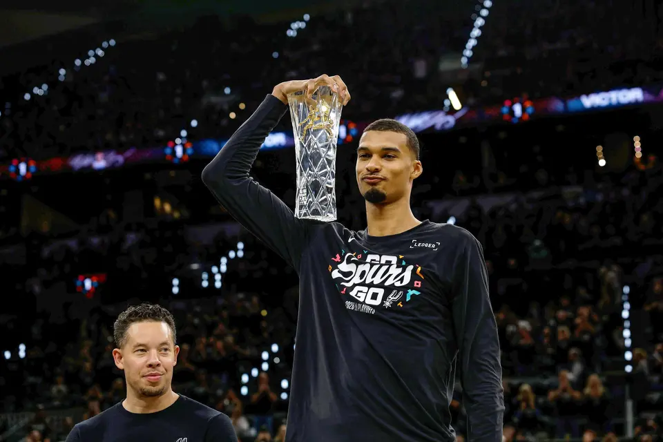Victor Wembanyama holds up his Defensive Player of the Year trophy before Game 2 against Portland at Frost Bank Center on Tuesday, April 21, 2026.