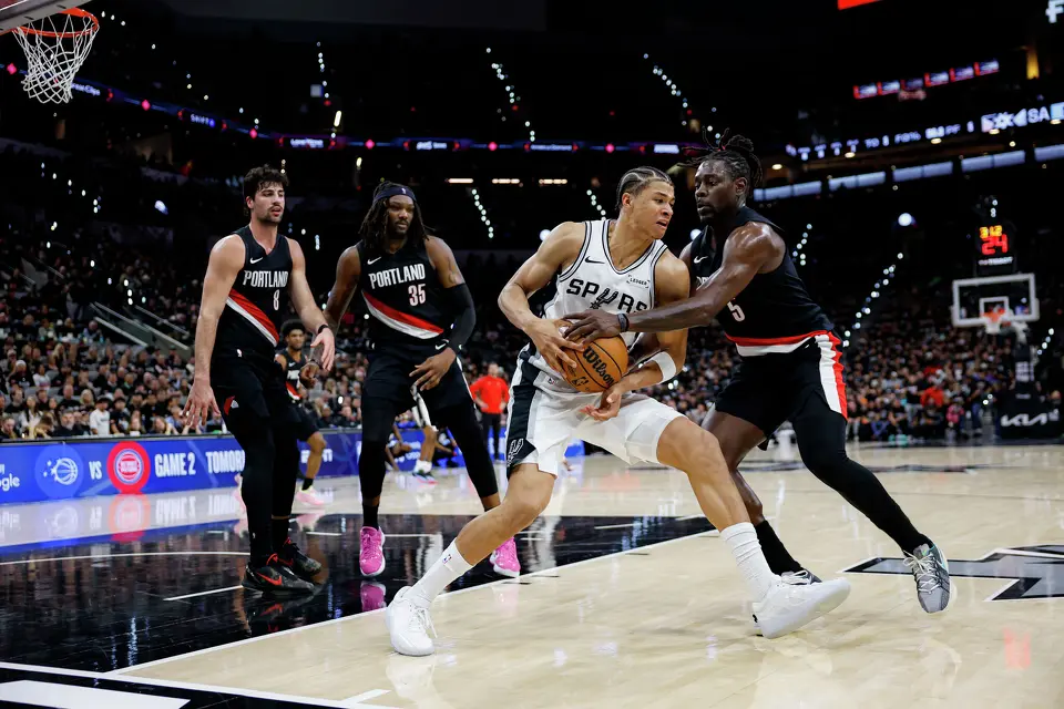 San Antonio Spurs forward Carter Bryant (11) keeps the ball away from Portland Trail Blazers guard Jrue Holiday (5) during the first half of Game 2 of a first-round NBA playoff series between the San Antonio Spurs and the Portland Trail Blazers at Frost Bank Center in San Antonio, Tuesday, April 21, 2026.