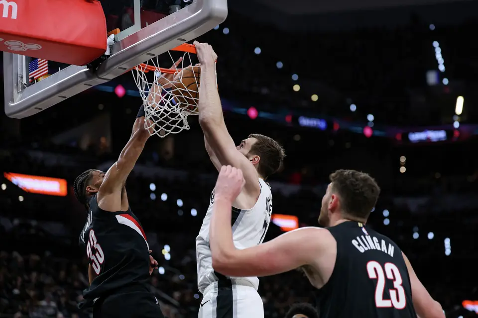 San Antonio Spurs center Luke Kornet (7) dunks over Portland Trail Blazers forward Toumani Camara (33) and center Donovan Clingan (23) during the first half of Game 2 of a first-round NBA playoff series at Frost Bank Center in San Antonio, Tuesday, April 21, 2026.