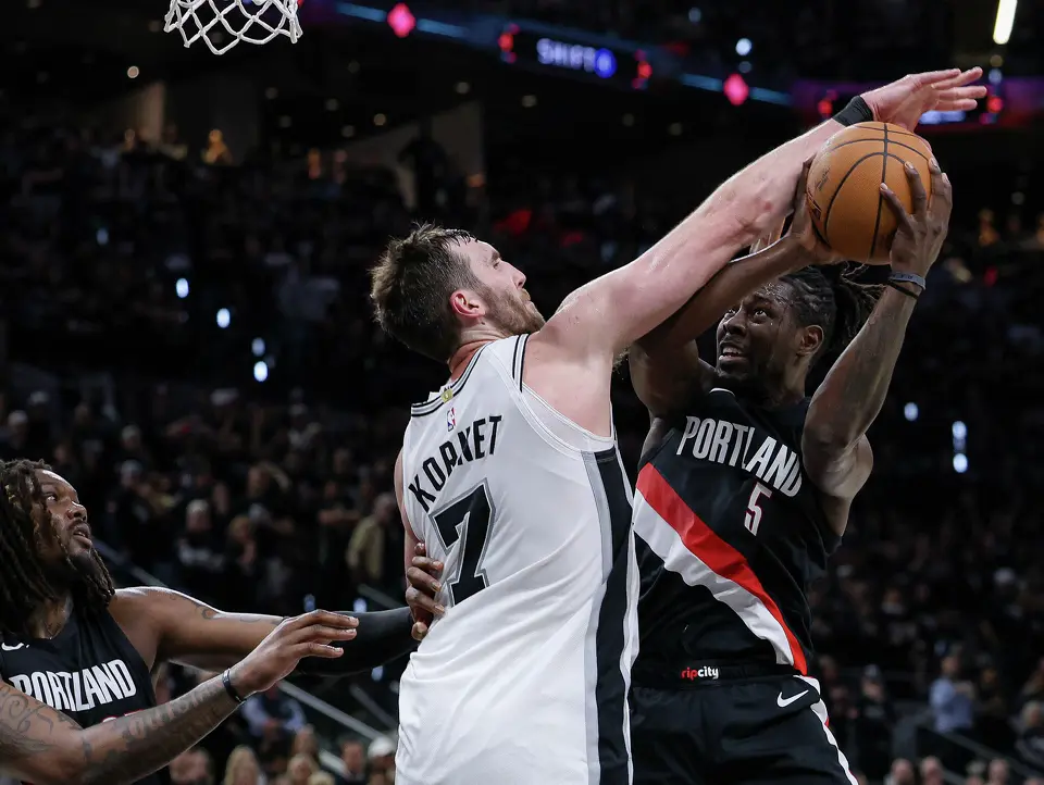 San Antonio Spurs center Luke Kornet (7) blocks Portland Trail Blazers guard Jrue Holiday (5) under the net during the second half of Game 2 of a first-round NBA playoff series at Frost Bank Center in San Antonio, Tuesday, April 21, 2026. The Spurs fell 106-103, evening the series at 1-1.