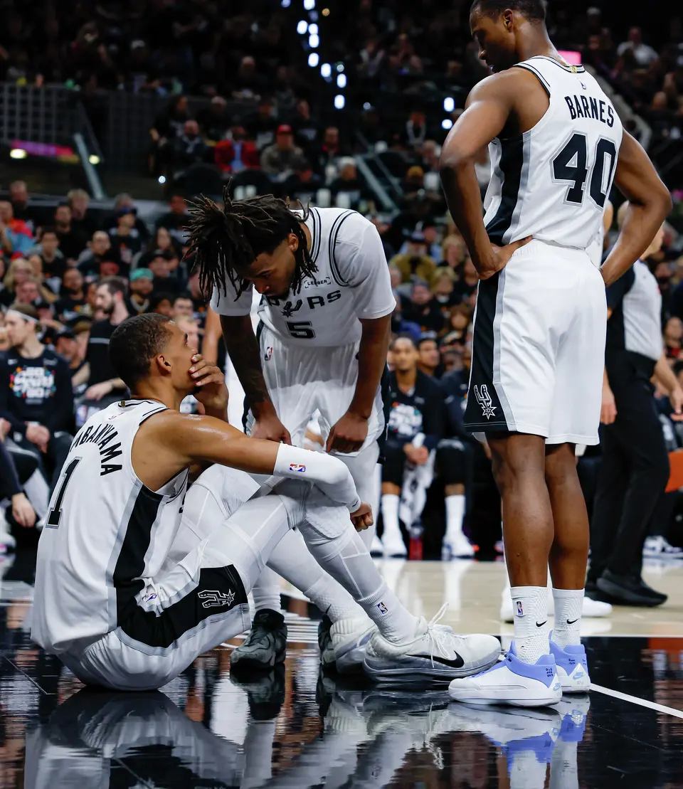 San Antonio Spurs forward Victor Wembanyama (1) talks with teammate Stephon Castle after taking a hard fall before leaving for the locker room during the first half of Game 2 of a first-round NBA playoff series against the Portland Trail Blazers, Tuesday, April 21, 2026, in San Antonio. Wembanyama did not return to the game.
