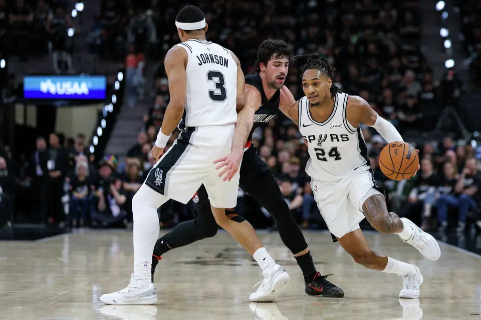 San Antonio Spurs forward Keldon Johnson (3) sets a pick for guard Devin Vassell (24) as he drives past Portland Trail Blazers forward Deni Avdija (8) during the first half of Game 2 of a first-round NBA playoff series at Frost Bank Center in San Antonio, Tuesday, April 21, 2026.