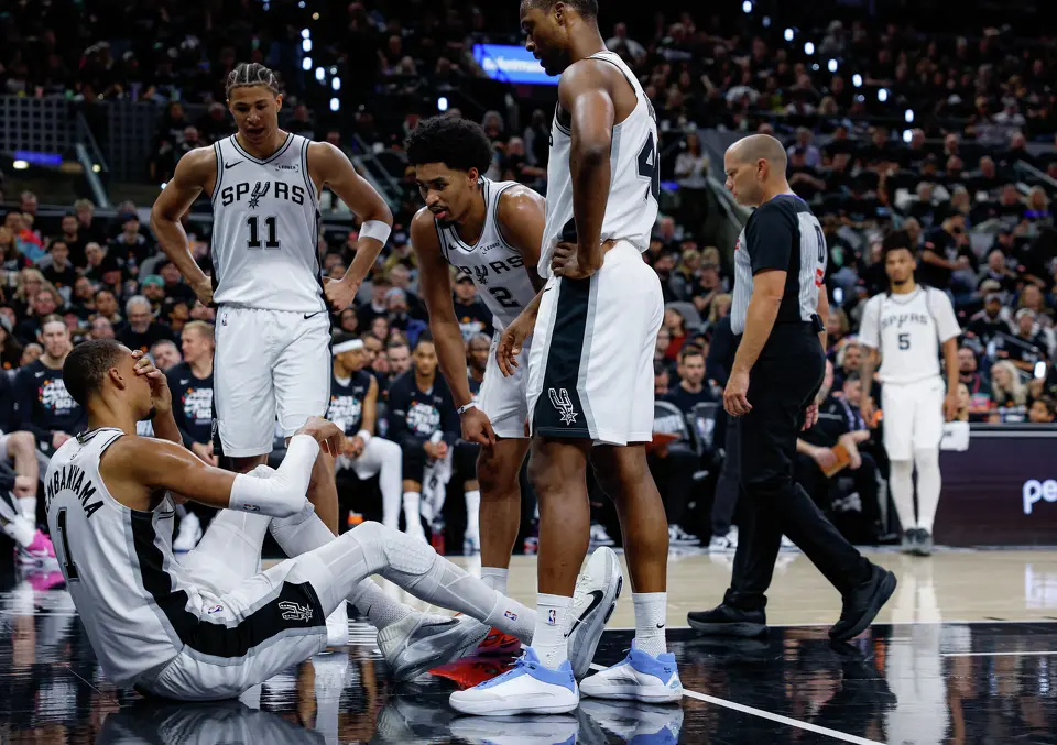 Victor Wembanyama sits on the court after taking a hard fall during the first half of Game 2 of a first-round NBA playoff series against the Portland Trail Blazers, Tuesday, April 21, 2026, in San Antonio. He did not return to the game.