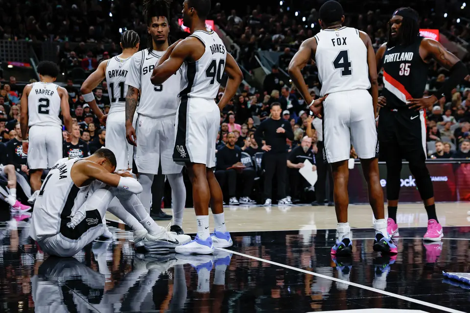 Victor Wembanyama sits on the court after taking a hard fall during the first half of Game 2 of a first-round NBA playoff series against the Portland Trail Blazers, Tuesday, April 21, 2026, in San Antonio. He did not return to the game.