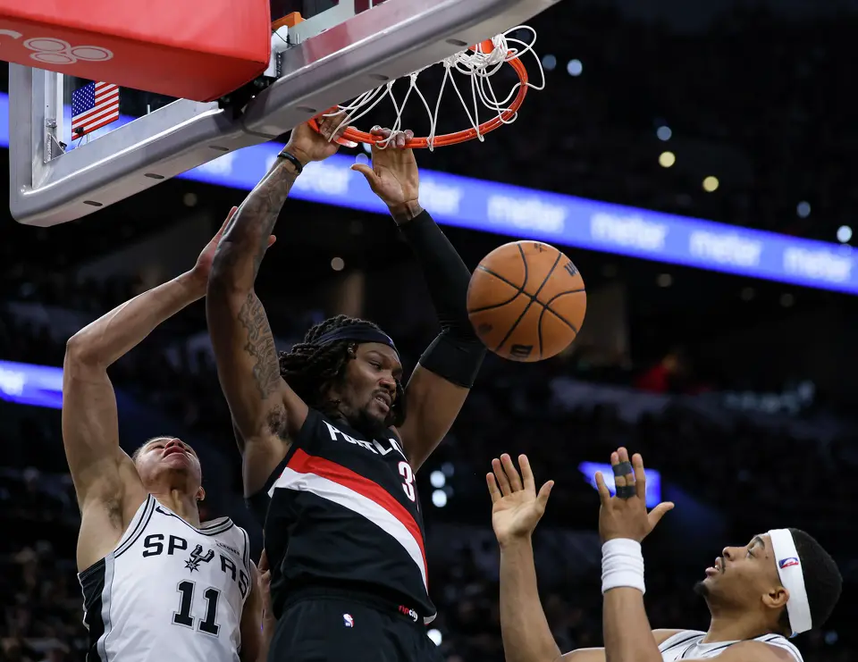 Portland Trail Blazers center Robert Williams III (35) dunks over San Antonio Spurs forward Carter Bryant (11) and forward Keldon Johnson (3) during the second half of Game 2 of a first-round NBA playoff series at Frost Bank Center in San Antonio, Tuesday, April 21, 2026. The Spurs fell 106-103, evening the series at 1-1.