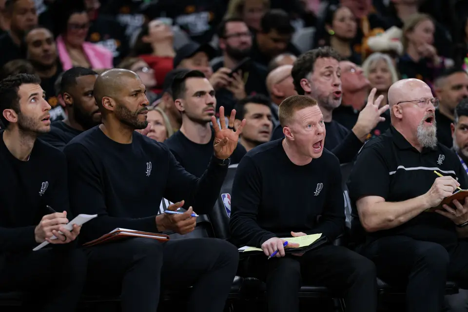 San Antonio Spurs associate head coach Sean Sweeney, second from right, yells from the bench during the second half of Game 2 of a first-round NBA playoff series against the Portland Trail Blazers at Frost Bank Center in San Antonio, Tuesday, April 21, 2026. The Spurs fell 106-103, evening the series at 1-1.