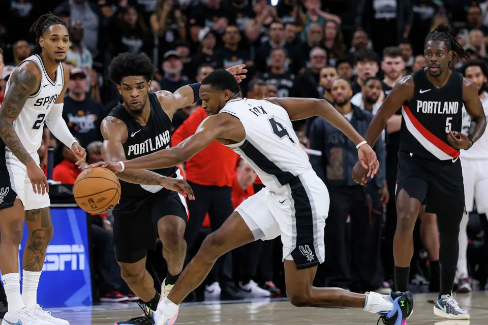 San Antonio Spurs guard De’Aaron Fox (4) recovers a loose ball as Portland Trail Blazers guard Scoot Henderson (00) defends during the second half of Game 2 of a first-round NBA playoff series at Frost Bank Center in San Antonio, Tuesday, April 21, 2026. The Spurs lost 106-103, tying the series 1-1.