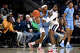 Columbia guard Avery Brown (1) is guarded by UConn guard Malachi Smith (0) as UConn football player Skyler Bell, far left holds hits cell phone up in the first half of an NCAA college basketball game, Monday, Nov. 10, 2025, in Storrs, Conn. (AP Photo/Jessica Hill)