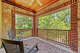 A private upstairs balcony overlooks mature trees.