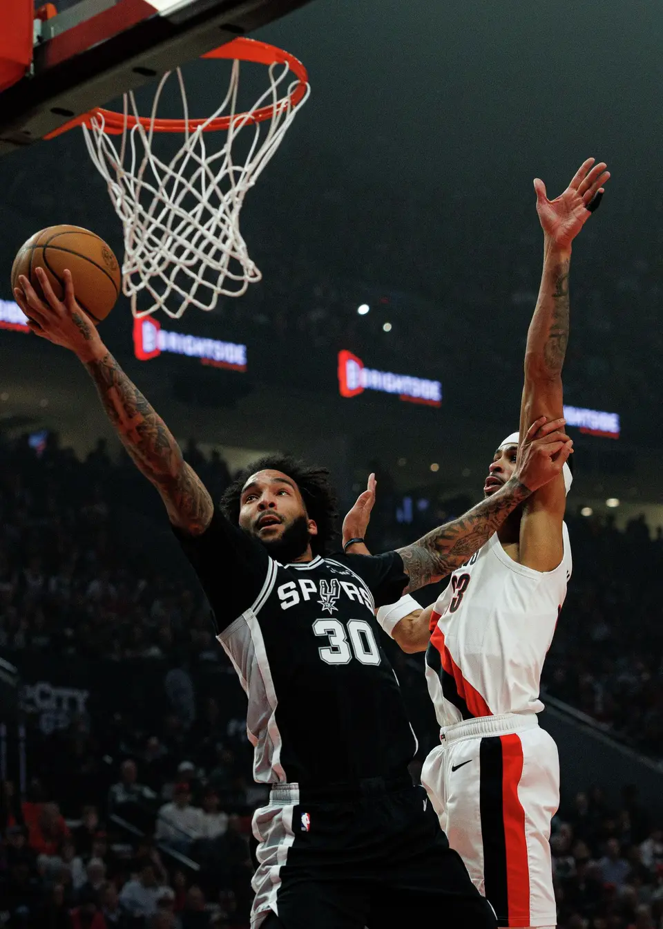 San Antonio Spurs forward Julian Champagnie (30) lays the ball in around Portland Trail Blazers forward Toumani Camara (33) during the first quarter of Game 3 of a first-round NBA playoff series at Moda Center in Portland, Friday, April 24, 2026.
