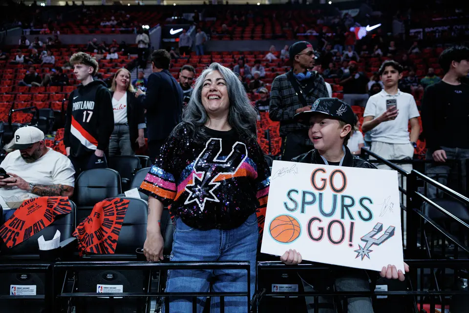 San Antonio Spurs fans Melissa Hernandez Marmolejo and her nephew Miles Orsborn, 8, watch the Spurs warm up on the court before Game 3 of a first-round NBA playoff series against the Portland Trail Blazers at Moda Center in Portland, Friday, April 24, 2026.
