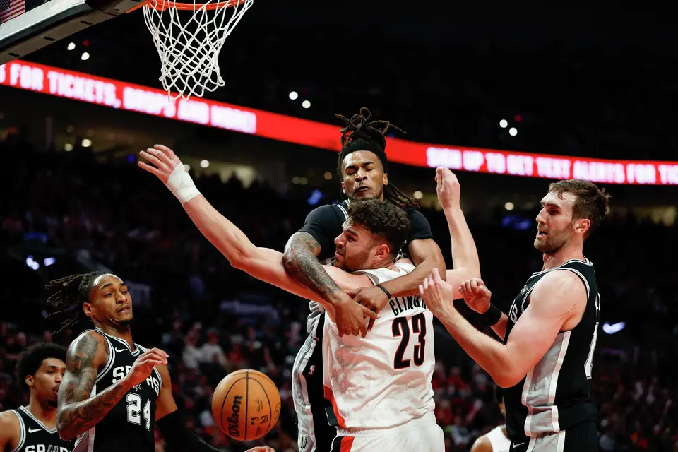 San Antonio Spurs guard Stephon Castle (5) hooks his arms around Portland Trail Blazers center Donovan Clingan (23) as they fight for the rebound during the second quarter of Game 3 of a first-round NBA playoff series at Moda Center in Portland, Friday, April 24, 2026. The Spurs defeated the Trail Blazers 120-108 to lead the series 2-1.