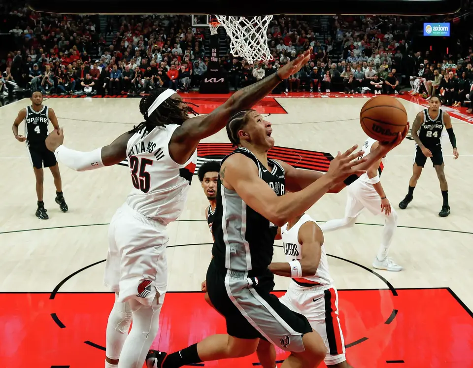San Antonio Spurs forward Carter Bryant (11) goes up for a shot around Portland Trail Blazers center Robert Williams III (35) during Game 3 of a first-round NBA playoff series at Moda Center in Portland, Friday, April 24, 2026. The Spurs defeated the Trail Blazers 120-108 to lead the series 2-1.