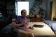 Scott Wheeler, 62, sits on his bed in his apartment and listens to a Social Security Administration representative explain what his monthly benefits will be during a phone appointment to apply early in Dallas, April 7, 2026. About two years ago, Wheeler was laid off from his job of 25 years. He started DoorDashing after spending all of his severance and 401(k) savings which he said totaled about $57,000.